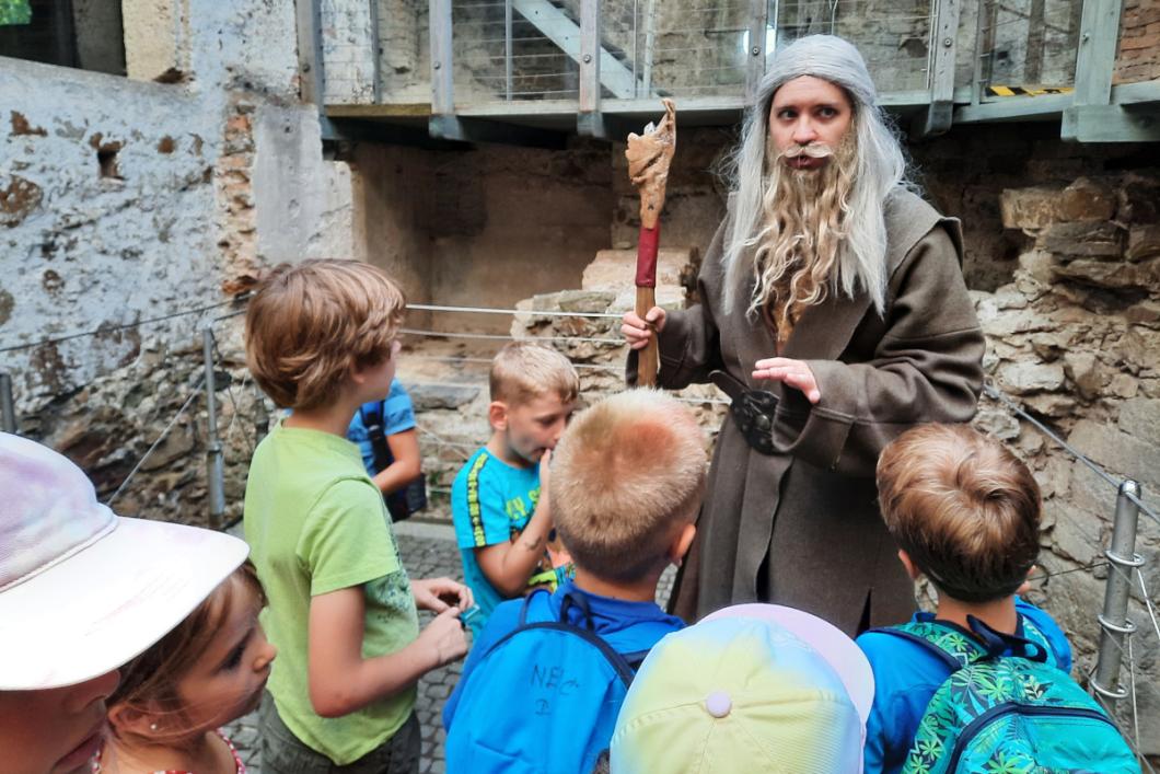 Šola zmajeslovja: Planet zmajev, profesor zmajeslovja z otroki. Foto: Miha Mally